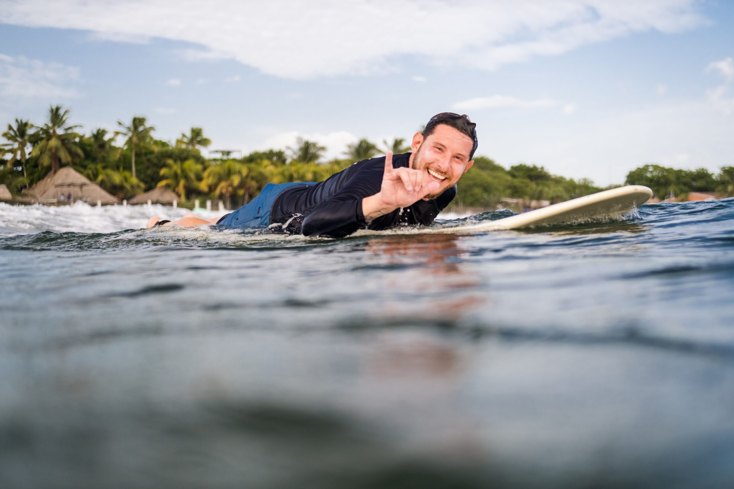 man laying on a board surfing Nicaragua