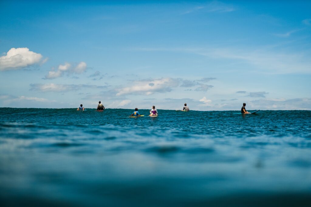 People Surfing in the Ocean and Talking About Bible Verses