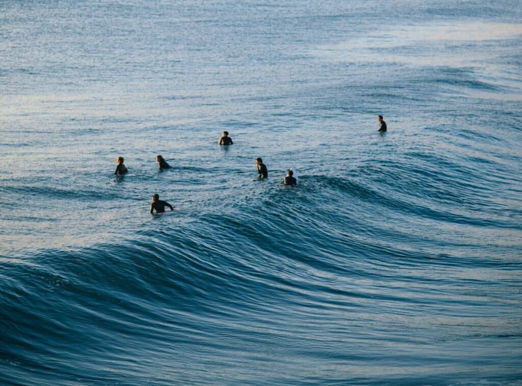 surfers praying in a surf circle