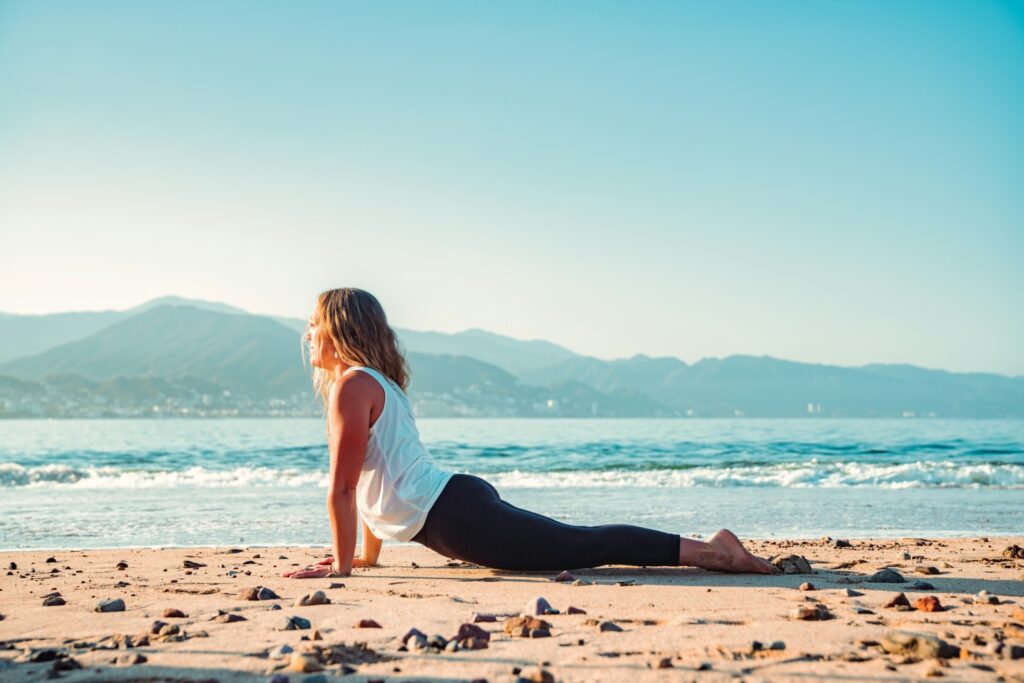 woman doing yoga on the beach