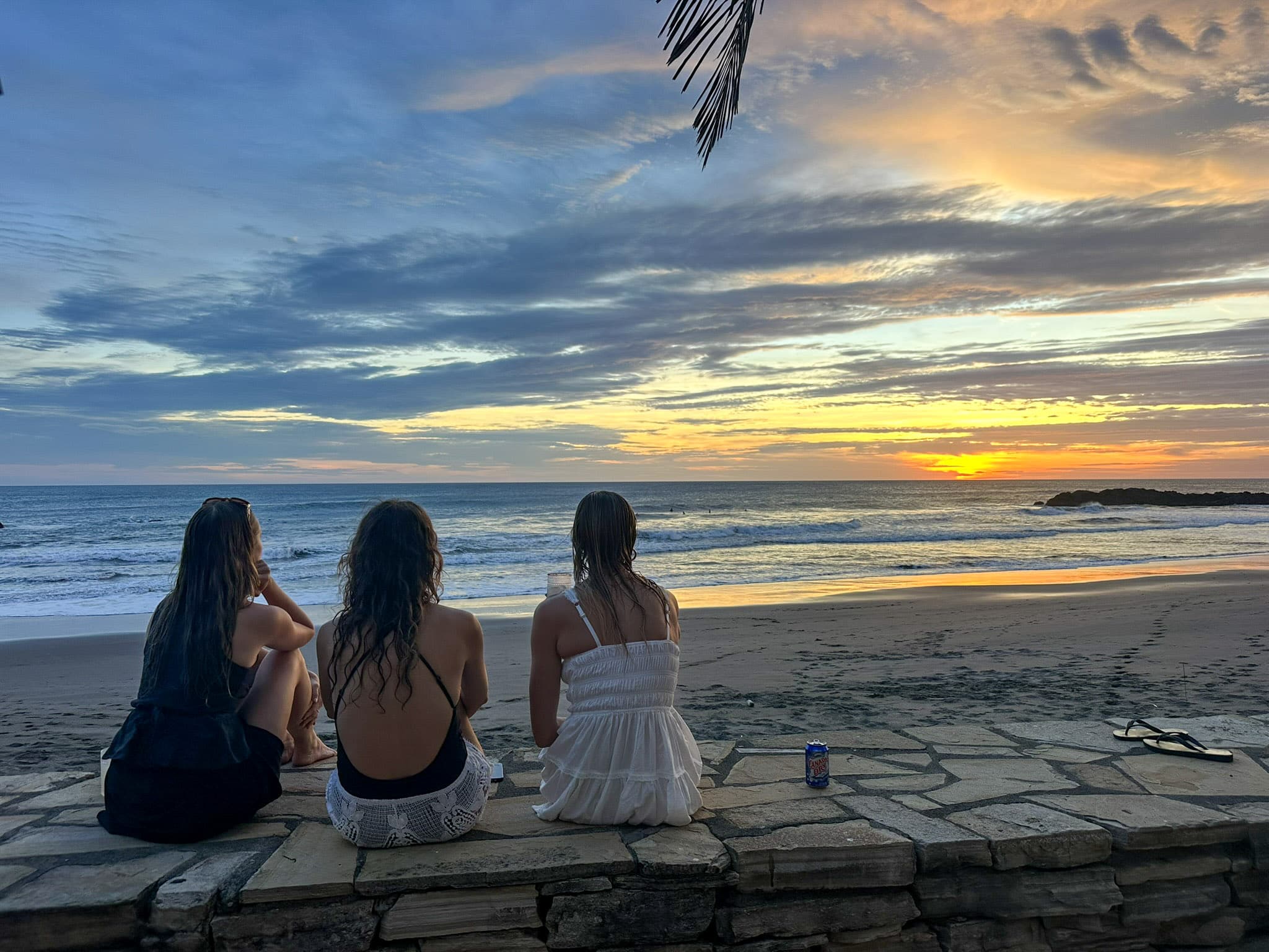 women sitting on beach after surfing